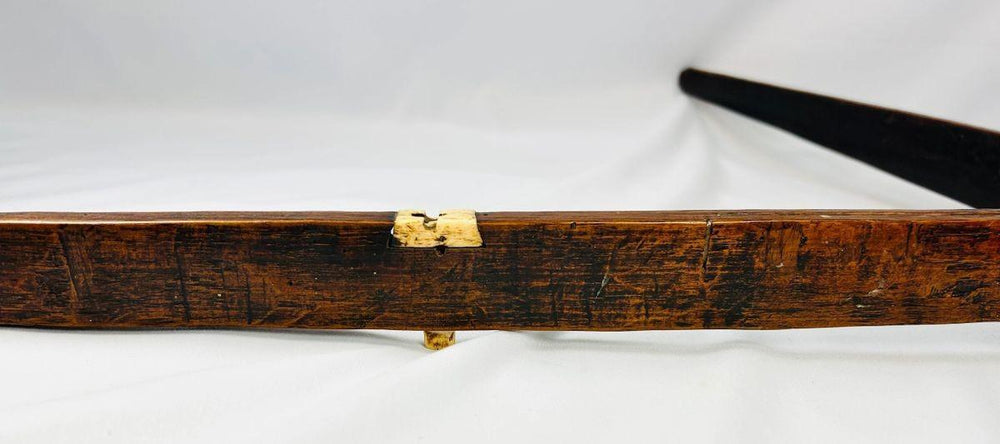 Close-up of Yunnan Nu tribal crossbow stock with carved mulberry wood and bone toggle.