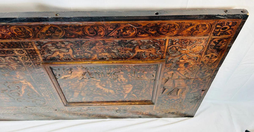 Antique carved wood panel showing heraldic shield, decorative borders, and mythological motifs from the Renaissance period.