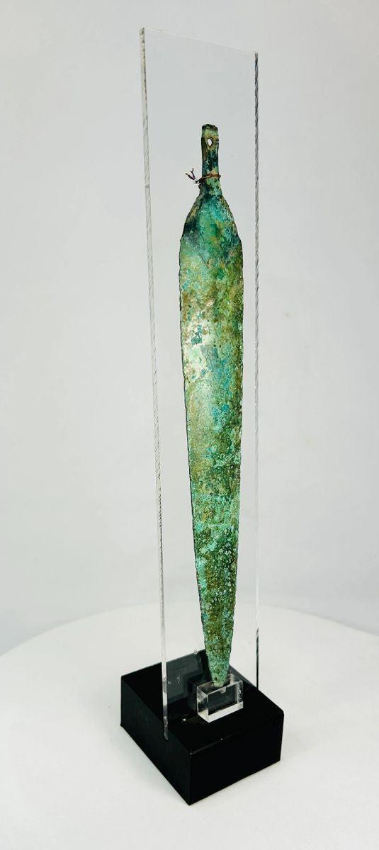 Detail photograph highlighting the central ridge and aged patina of a bronze dagger blade