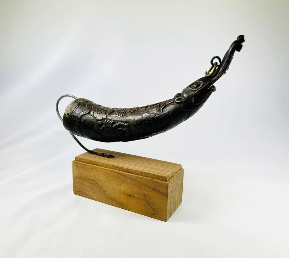 Close view of engraved Tibetan ritual horn for monastic fire ceremonies.