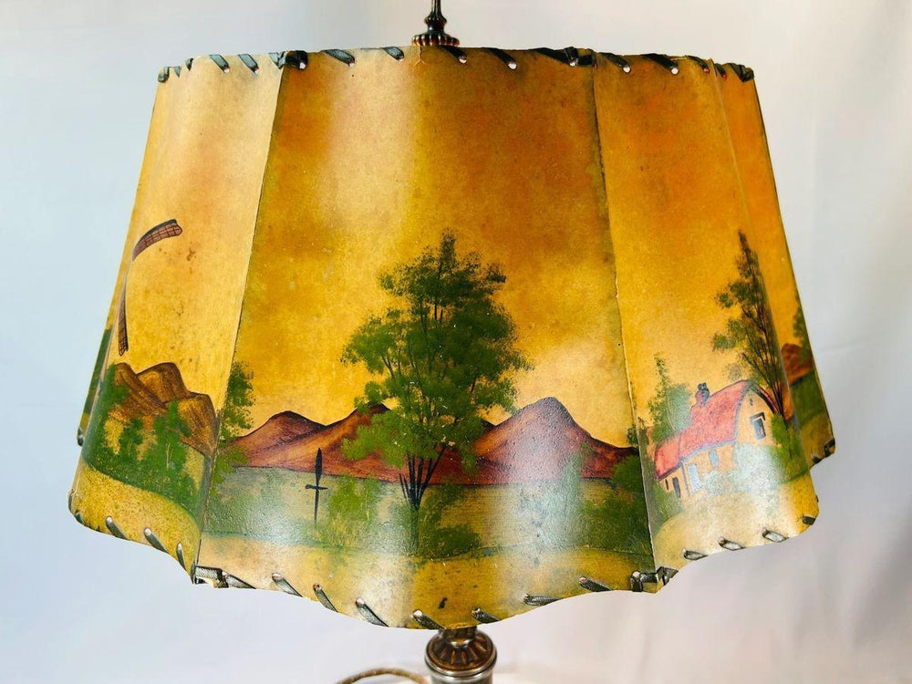 Early 20th century European table lamp featuring scenic painted parchment shade and ornate metal base