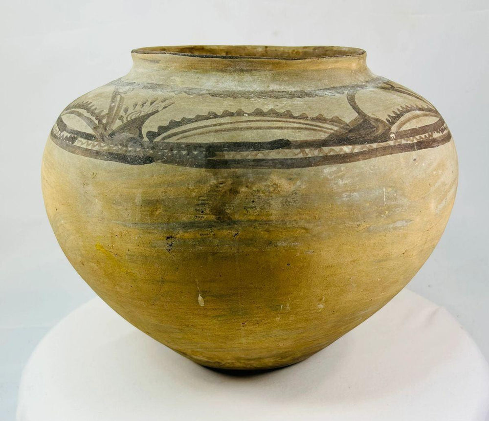 Hand-molded Neolithic pottery jar showing painted spiral and geometric motifs.
