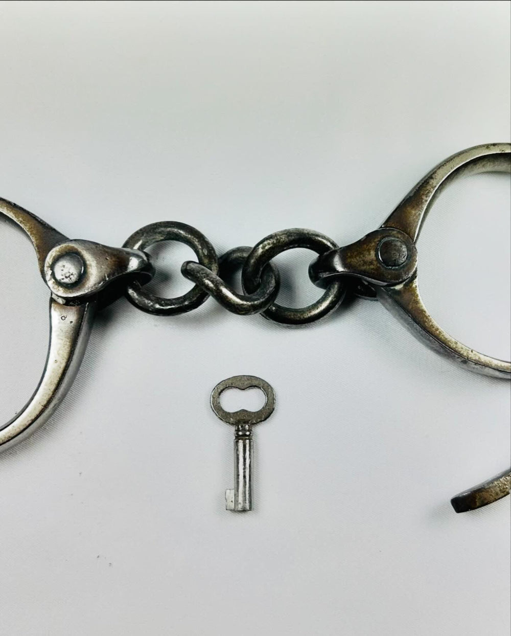 Early 1900s U.S. handcuffs, Tower Detective design, complete with key