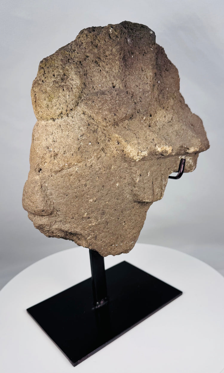 Weathered West African stone head fragment mounted on a custom black stand