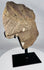 Weathered carved stone human head with mineral deposits and age-related patina