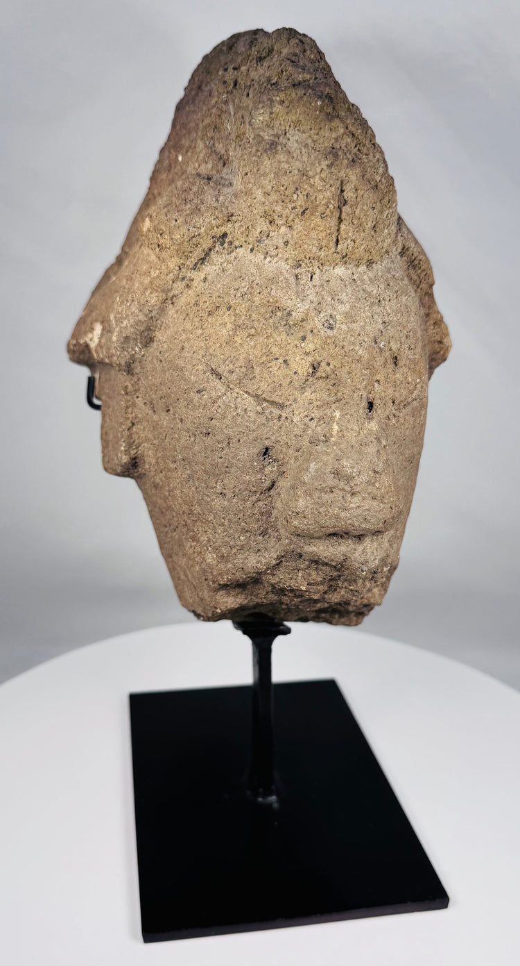 African sculptural stone fragment with conical headdress and solemn expression