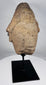 African sculptural stone fragment with conical headdress and solemn expression