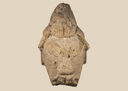 African carved stone head fragment with conical headdress on black metal display stand