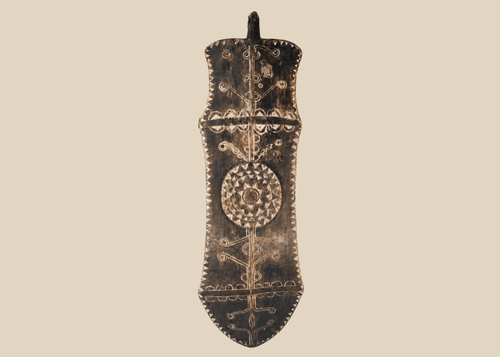 African carved wooden ceremonial shield with geometric decoration and central circular medallion