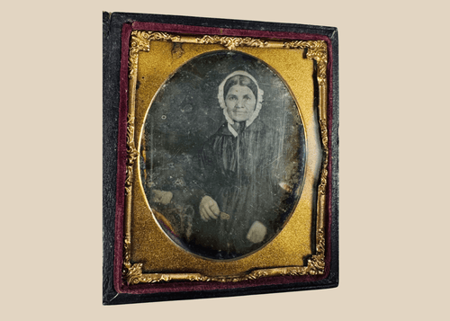 Sixth-plate daguerreotype portrait of a woman wearing a white bonnet and dark dress