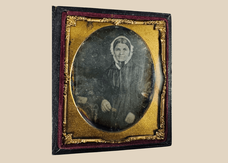 Sixth-plate daguerreotype portrait of a woman wearing a white bonnet and dark dress