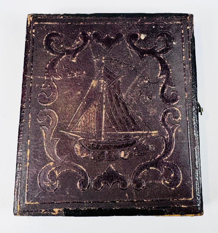 Early American daguerreotype housed in a crimson velvet-lined leatherette case
