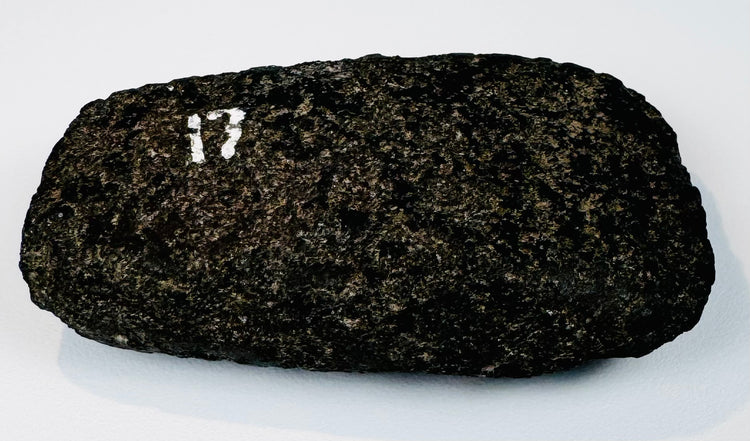 Ancient South American stone axe showing its rounded, resharpened cutting edge and compact hand-worked form.