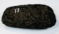 Ancient South American stone axe showing its rounded, resharpened cutting edge and compact hand-worked form.