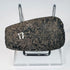 Angled view of an ancient Andean stone axe displaying its beveled edge and heavily worn archaeological surface.