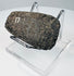 Detailed view of an ancient Ecuadorian or Peruvian ground stone axe with mottled mineral patina and surface wear.