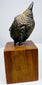 Thai bronze Buddha head with a long earlobe, curved jawline, and raised hair curls, supported above a wooden display base.
