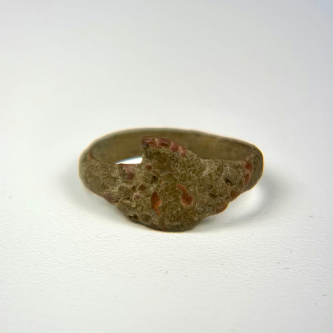 Ancient bronze ring featuring a robust circular band and simple geometric bezel form