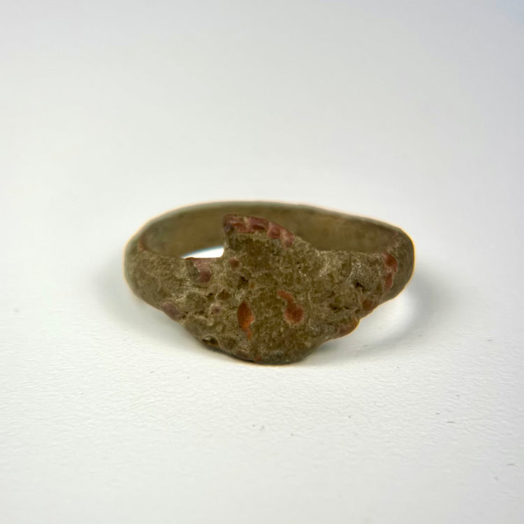 Ancient bronze ring featuring a robust circular band and simple geometric bezel form