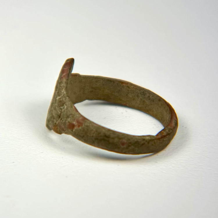 Ancient bronze jewelry with distinctive bezel, worn surface texture, and preserved historic character