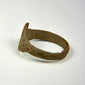 Ancient bronze jewelry with distinctive bezel, worn surface texture, and preserved historic character