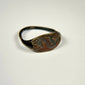 Historic bronze ring with oval animal-engraved bezel, green patination, and intact circular band