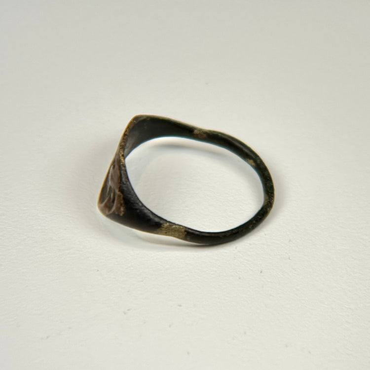 Ancient bronze signet-style ring displaying a horned bull motif on an oval bezel