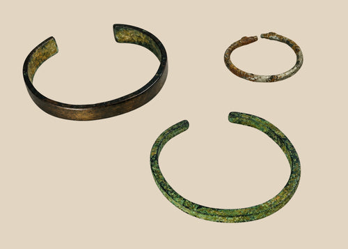 Rare set of three ancient bracelets from the Near East (Mesopotamia to Levant or Anatolia), Bronze to Iron Age (circa 6th millennium BCE – 7th century CE). Includes a broad bronze cuff with green patina, a slender oxidized bronze bracelet, and a textured iron bracelet, reflecting ancient metallurgical skill, decorative traditions, and cultural symbolism of personal adornment.