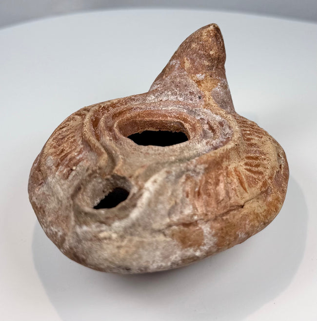 Ancient reddish-brown pottery oil lamp with herringbone-style incised decoration