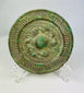 Han Dynasty bronze mirror, circa 206 BCE–220 CE, with engraved geometric and mythical motifs, central suspension knob, and rich green patina.