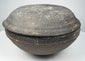 Tang Dynasty Chinese gray earthenware covered bowl in side profile, showing its compressed rounded form and fitted lid.
