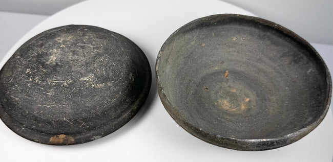 Ancient Chinese gray pottery covered bowl displayed open with lid and lower vessel side by side, showing the fitted two-part construction.