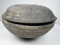 Side view of an ancient Chinese gray earthenware covered bowl with rounded lower body, fitted lid, and charcoal-gray patina.