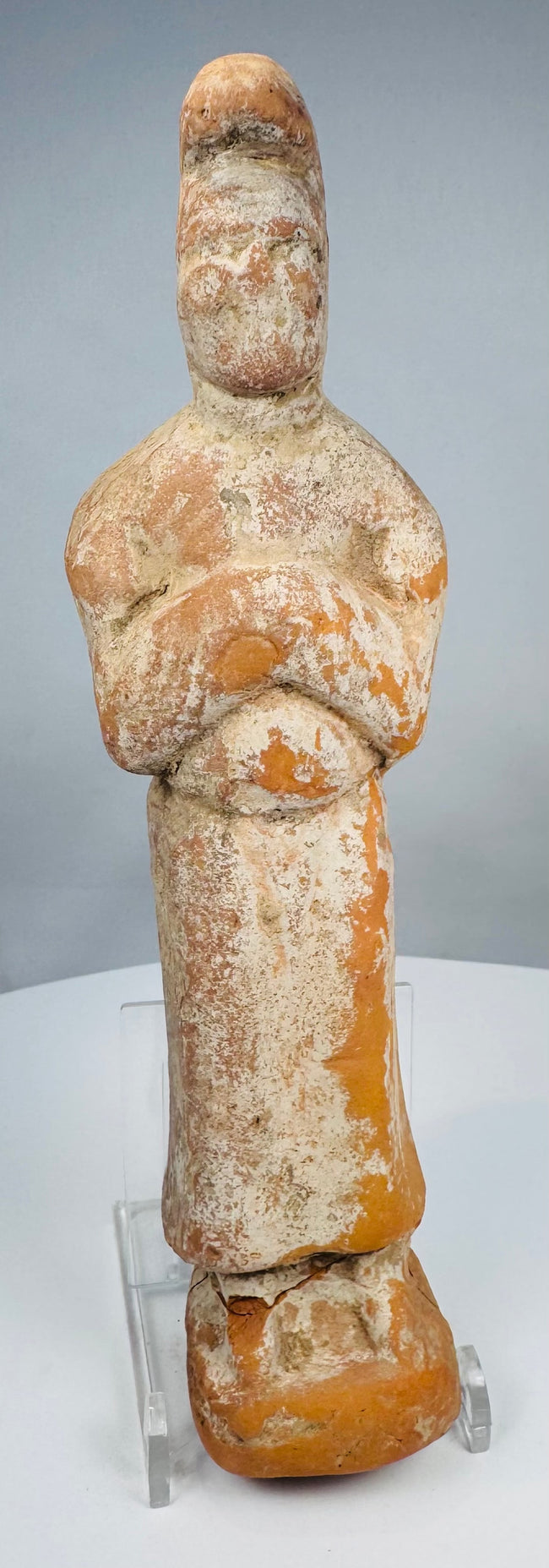Chinese Tang tomb attendant figure with tall curved headdress and pale slip