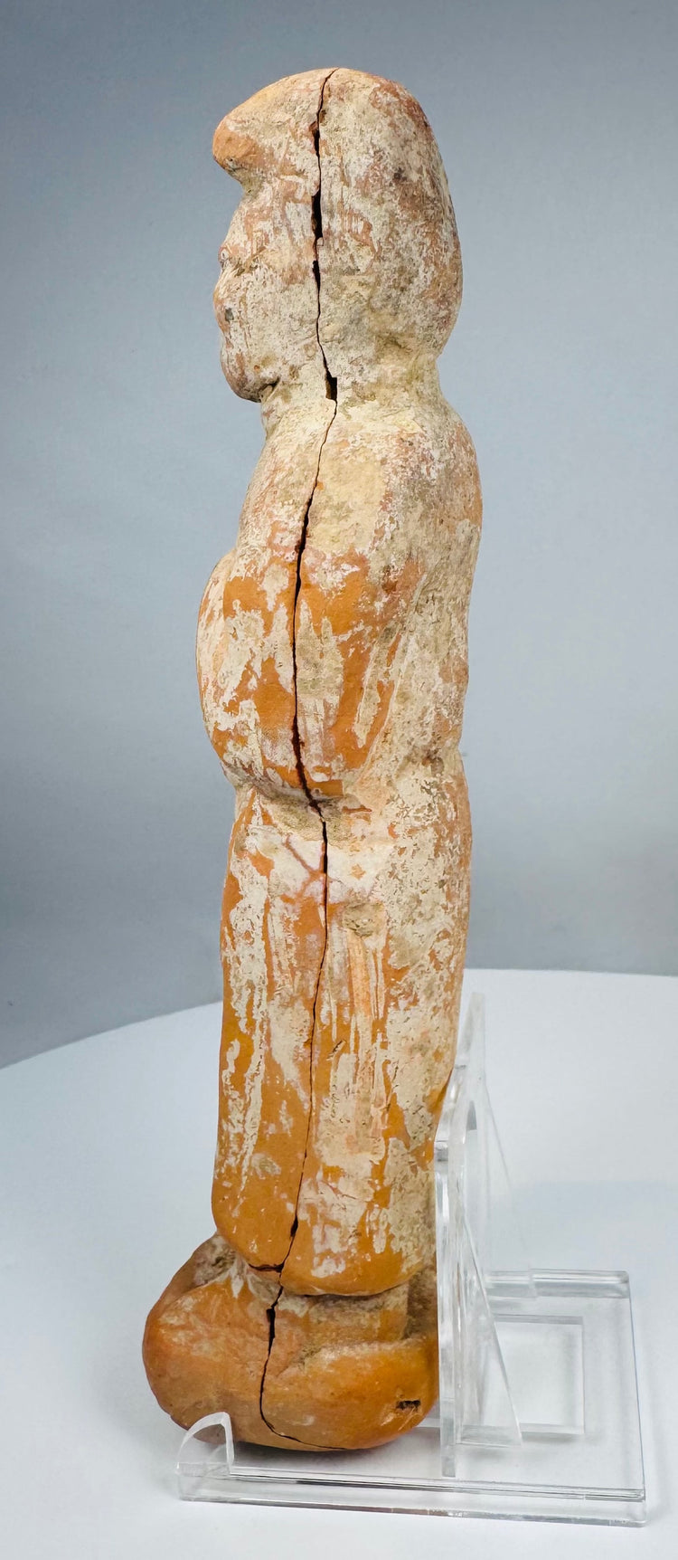 Ancient terracotta figure with floor-length robe and reddish-orange ceramic body