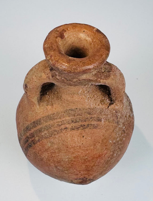 Close-up of black painted decoration on an orange-red Cypriot ceramic surface