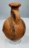 Side view of ancient Cyprus pottery vessel showing rounded body and flattened base