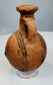 Side view of ancient Cyprus pottery vessel showing rounded body and flattened base