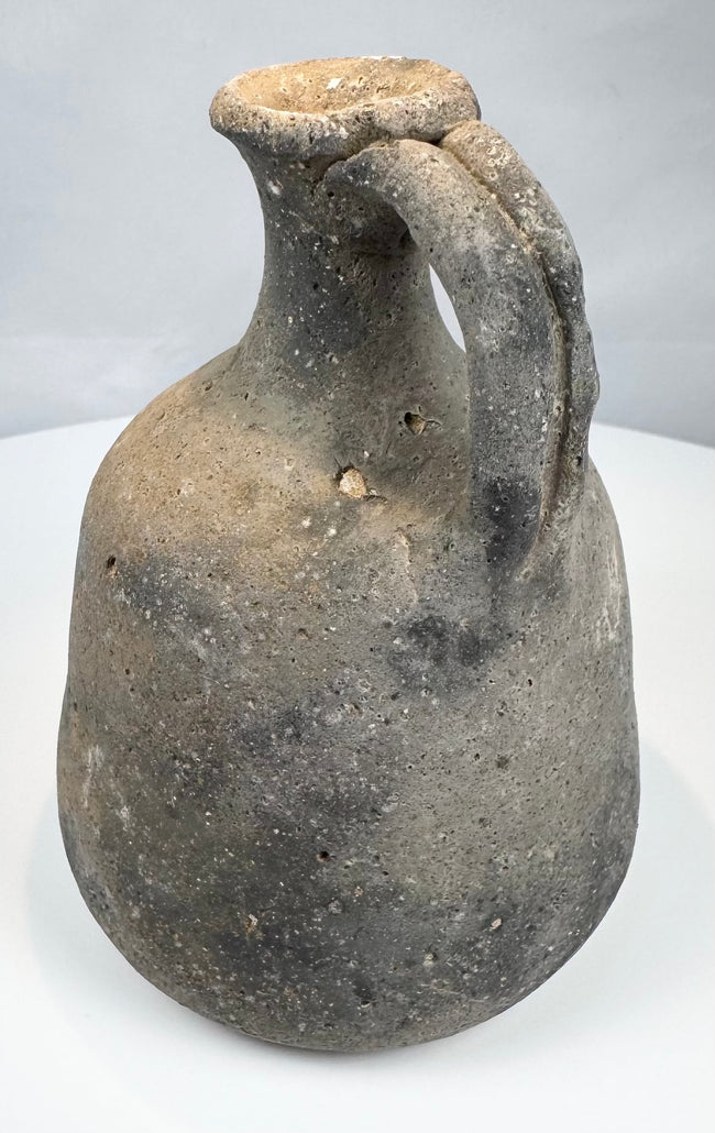 Small grey-brown earthenware jug for storing or pouring liquids