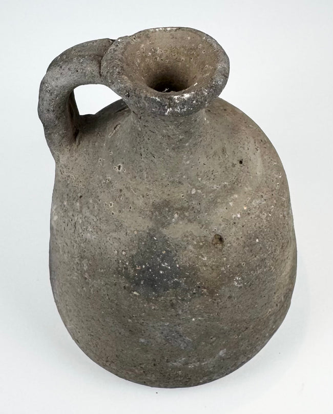 Ancient utilitarian pottery vessel with mineral inclusions and firing irregularities