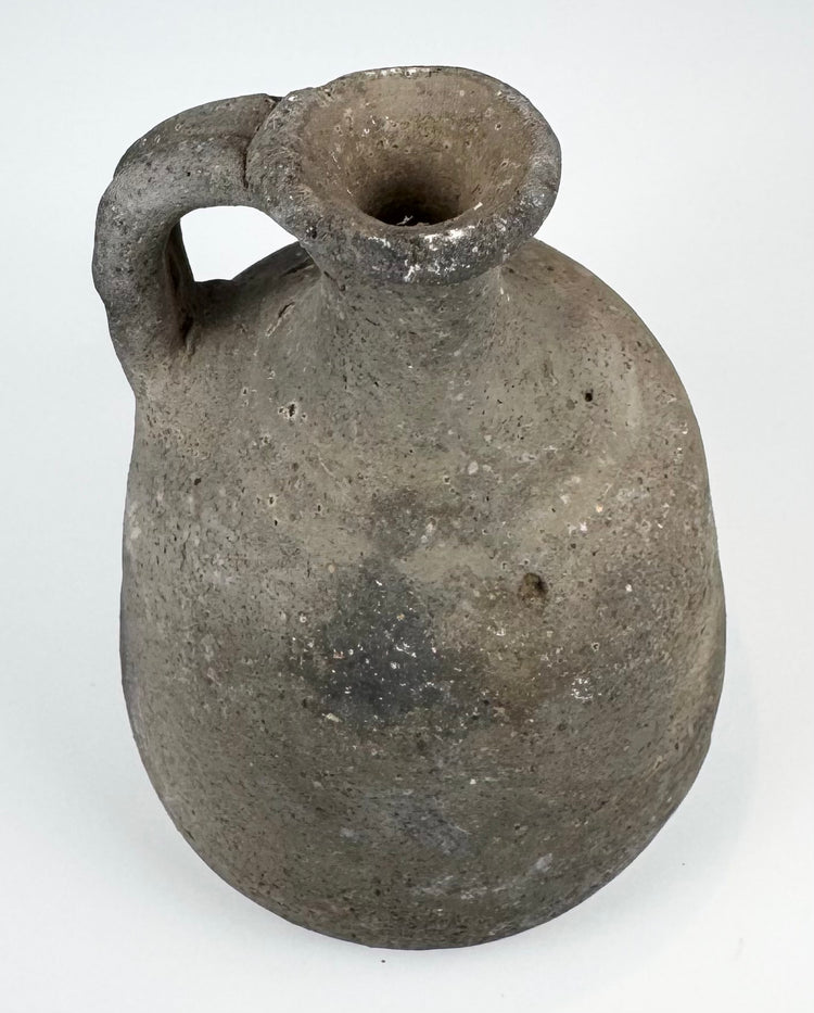 Ancient utilitarian pottery vessel with mineral inclusions and firing irregularities