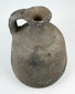 Ancient utilitarian pottery vessel with mineral inclusions and firing irregularities