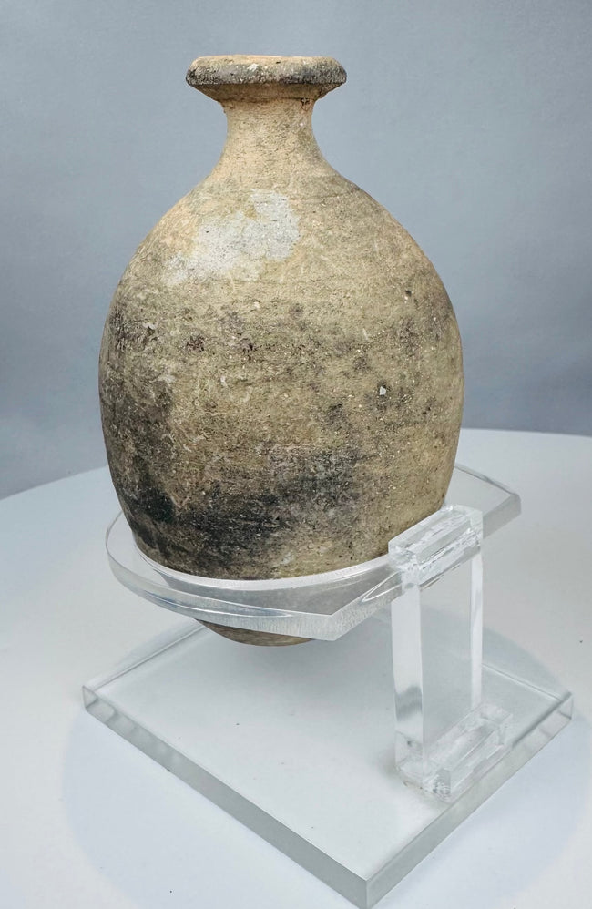 Side view of ancient ceramic flask showing ovoid profile and wheel-turning lines