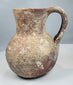 Compact ancient ceramic jug with globular belly and archaeological surface weathering