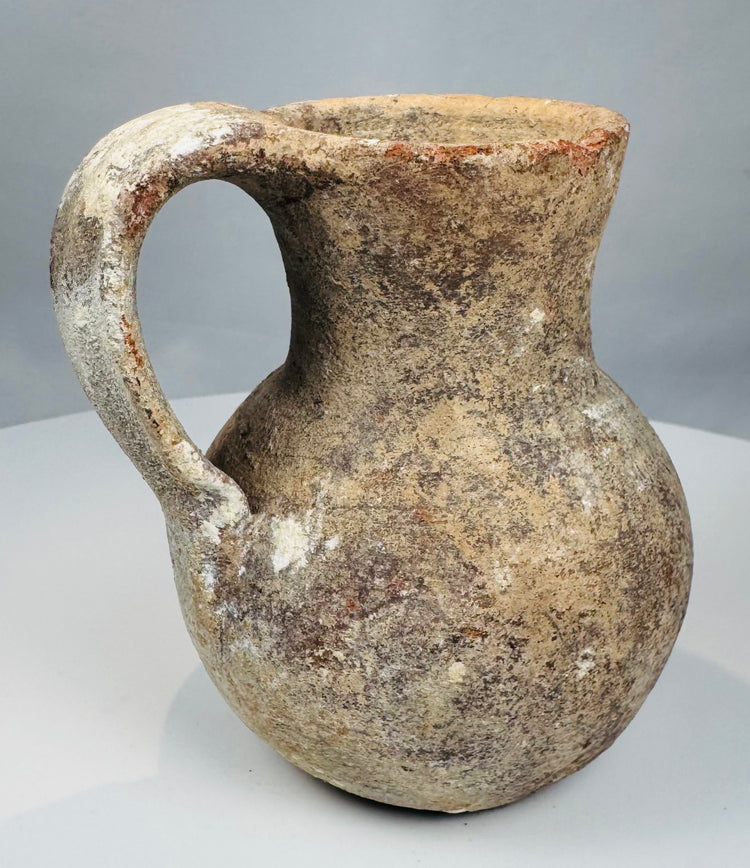 Side view of terracotta jug showing shaped pouring mouth and applied loop handle