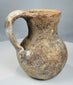 Side view of terracotta jug showing shaped pouring mouth and applied loop handle