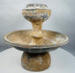 Ancient pedestal pottery vessel featuring a central raised receptacle for offerings