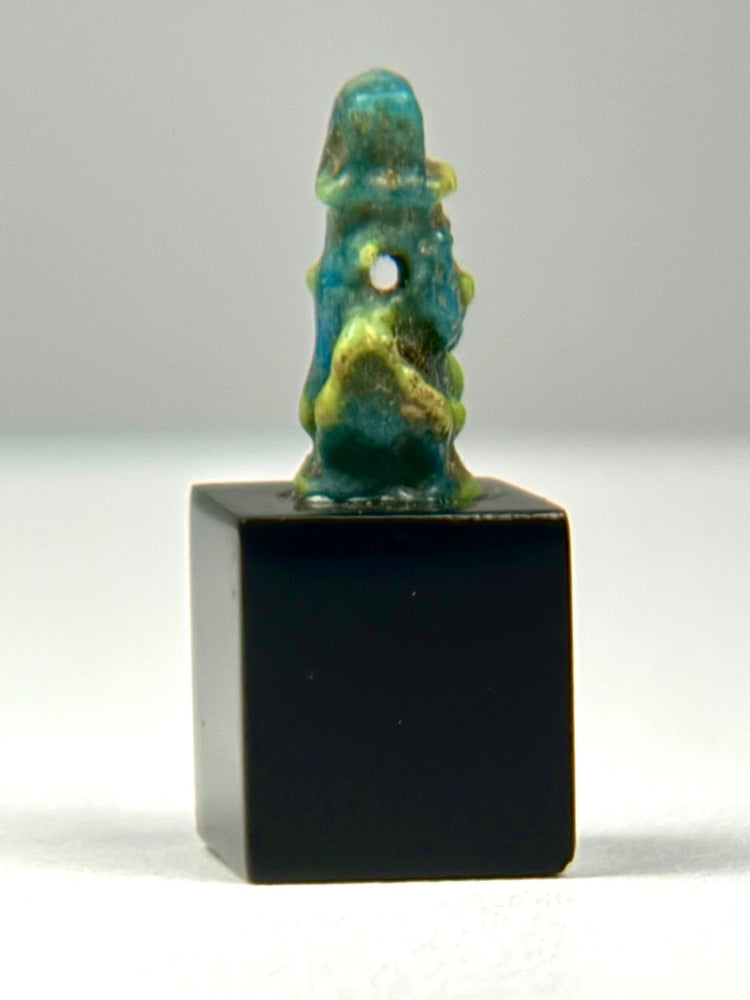 Close-up of perforation for stringing on Ancient Egyptian Bes faience amulet