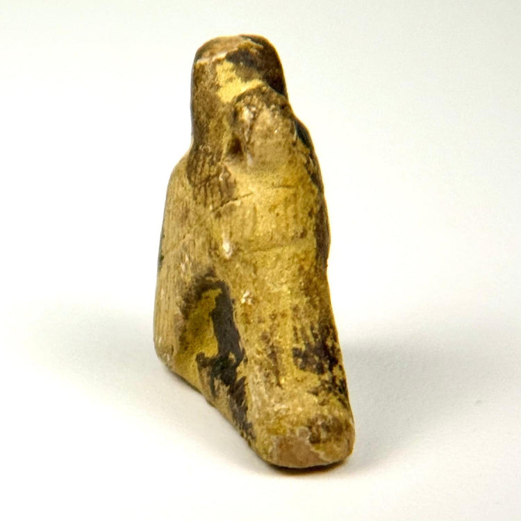 Rear view of Ancient Egyptian carved stone Horus bird figure showing weathered texture