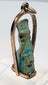 Reverse view of an ancient Egyptian amulet with weathered glaze and mineral deposits